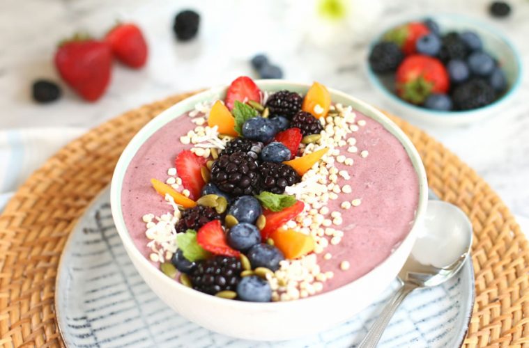 Mixed Berry and collagen peptide smoothie bowl topped with strawberries, blackberries, apricots, shredded coconut and pumpkin seeds.