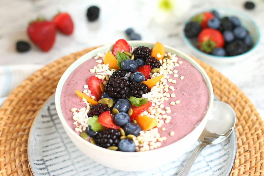 Mixed Berry and collagen peptide smoothie bowl topped with strawberries, blackberries, apricots, shredded coconut and pumpkin seeds.