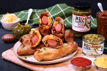 Chili Cheese Dog Egg Rolls Sliced on a plate with a mini foot ball ketchup mustard and Rio Luna Organic Nacho Sliced Jalapenos