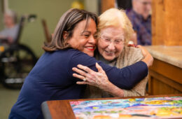 People hugging at a memory care facility